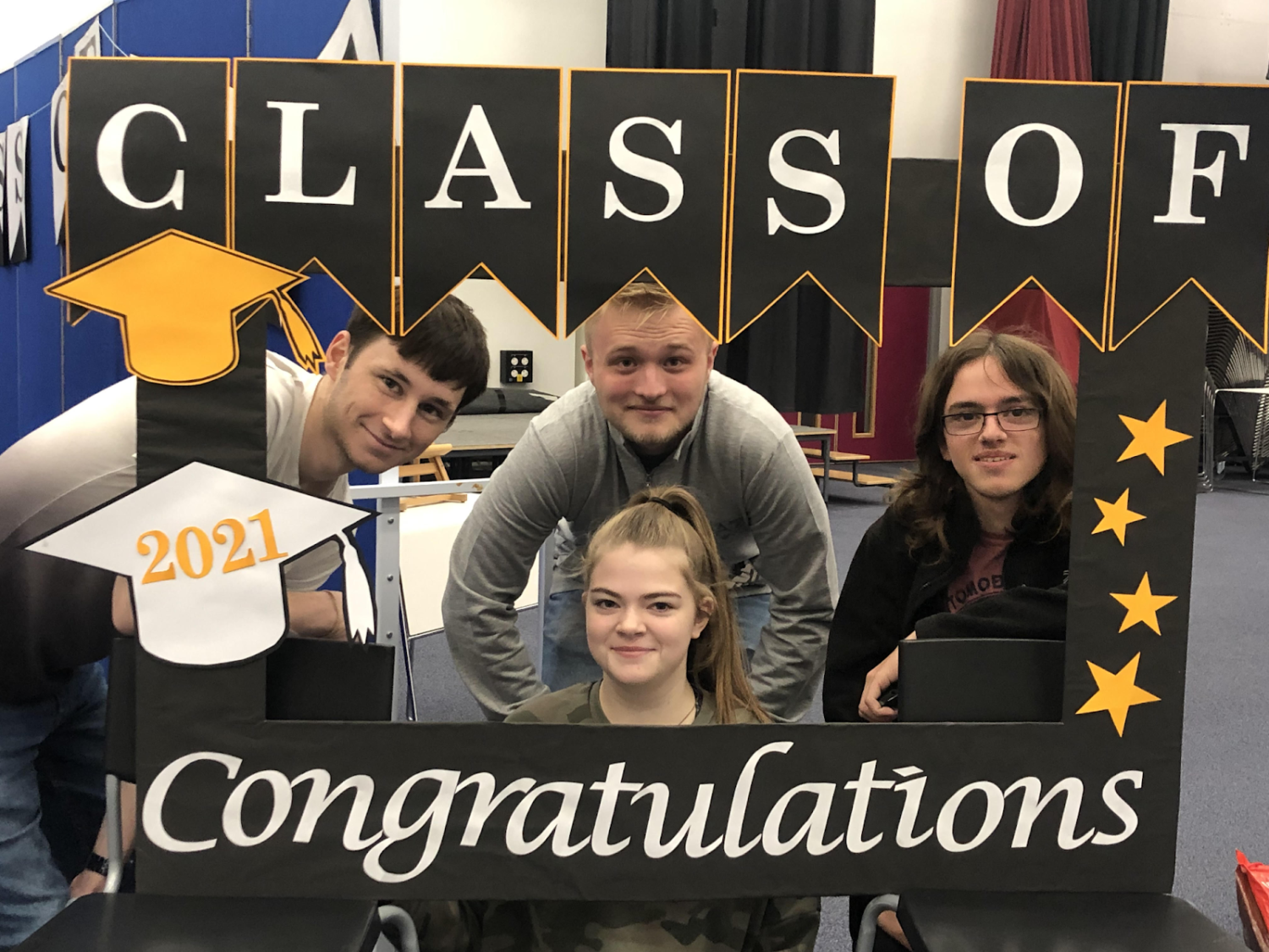 Four Post-16 students pose behind a display reading "Congratulations Class of 2021" on A Level Results Day.
