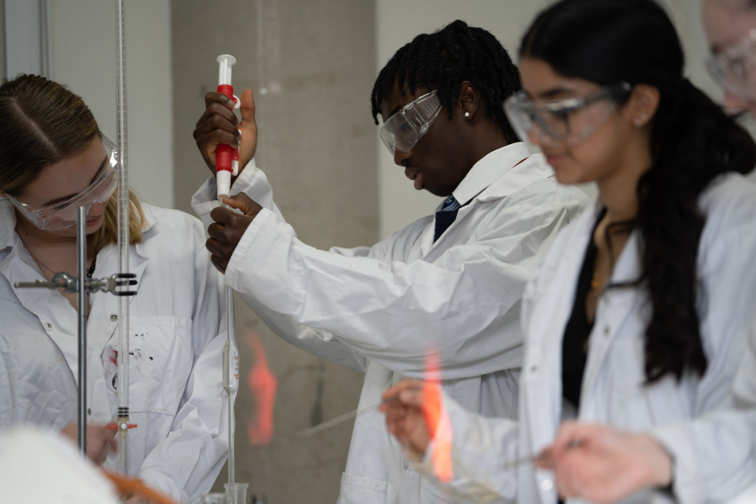 Three students working on an experiment during a chemistry lesson