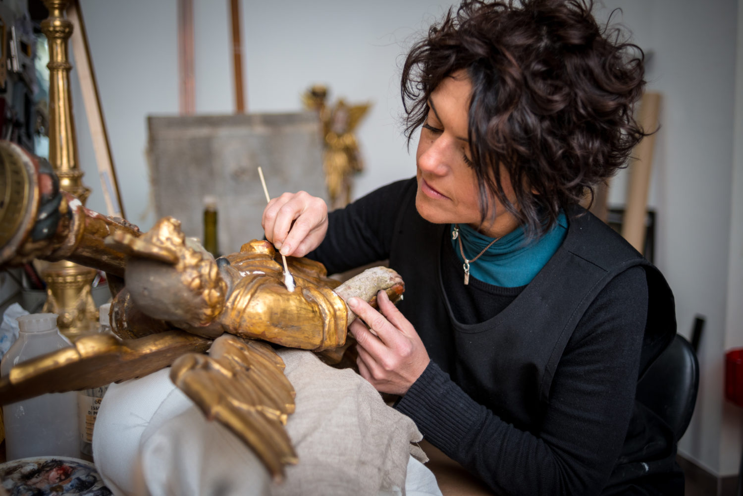 Restorer and framer laboratory craftswomen: Restoring antique golden angel statue