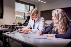 Two Sixth Form students writing in a classroom