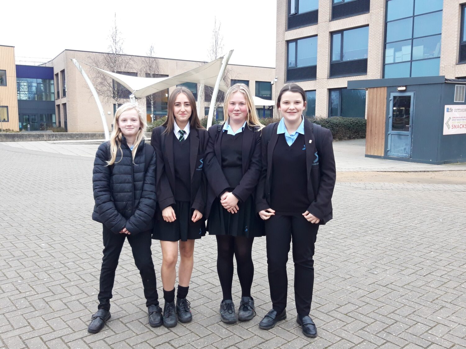 4 students in school uniform smiling