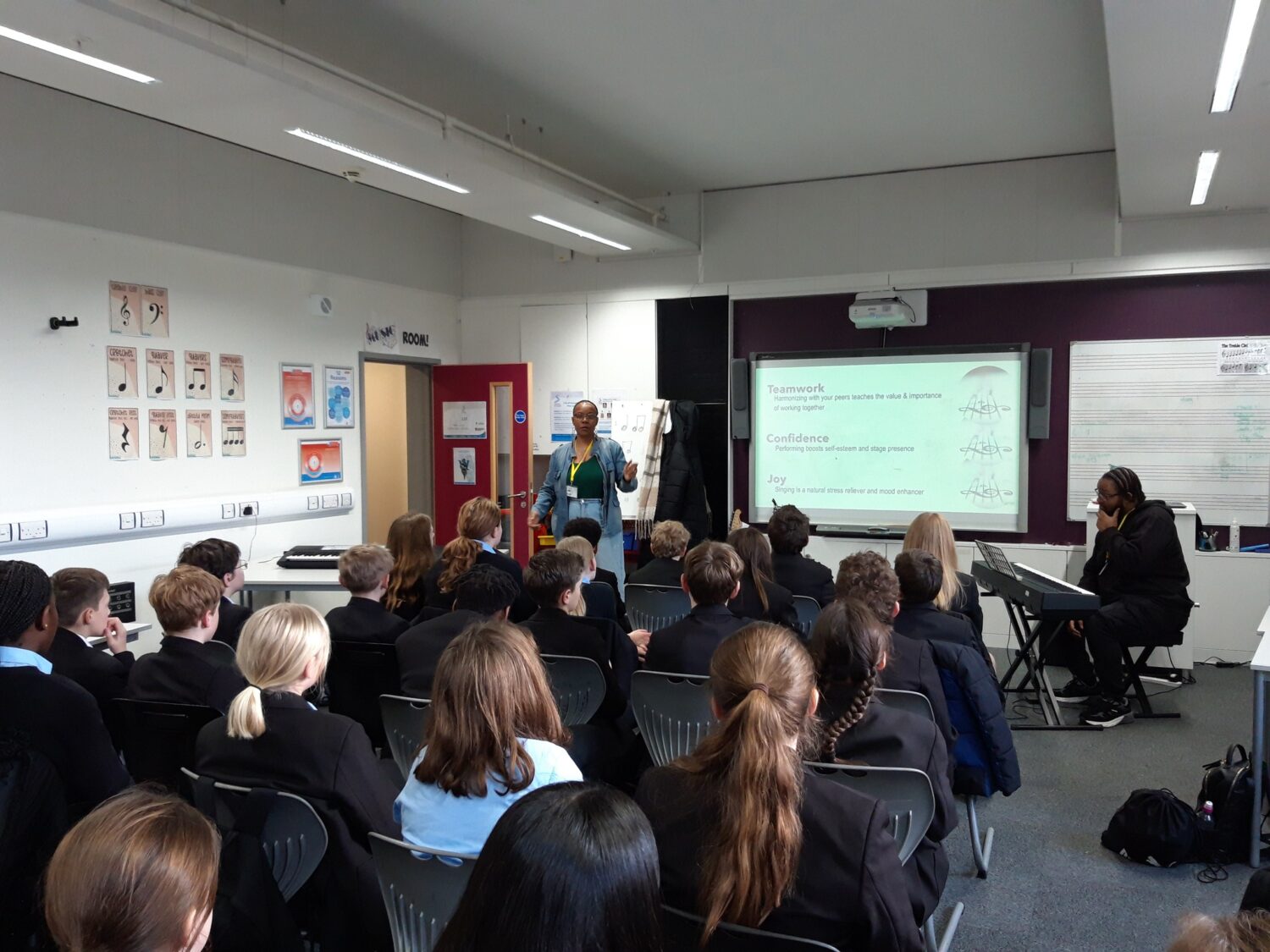 A group of students listening to a singing coach